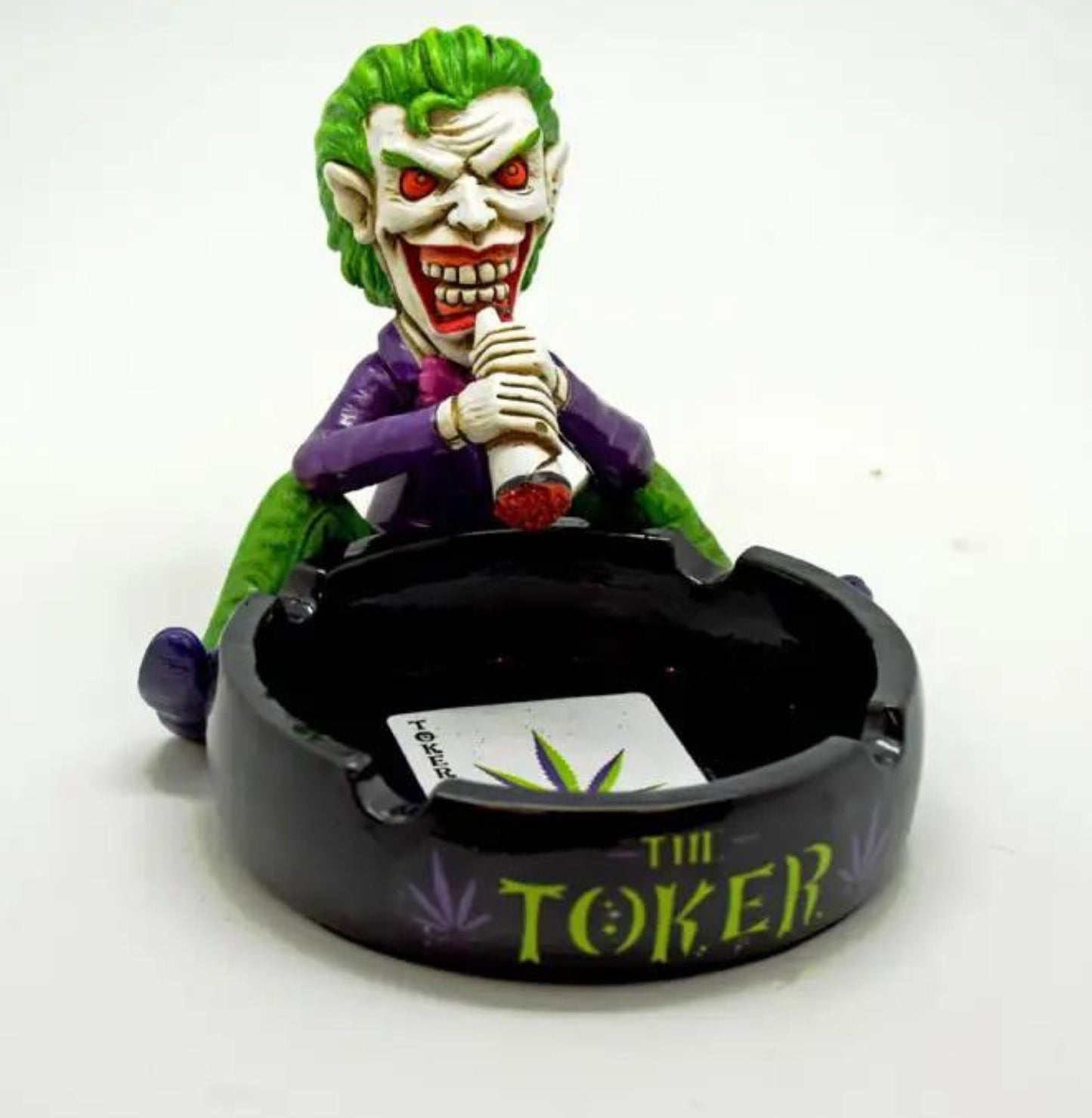 An Ashtray with the words &quot;The Toker&quot; in the front, a joker is smoking a Joint while sitting on the edge of the ashtray